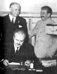 23 авуста 1939 г. В.М. Молотов подписывает советско-германский договор о ненападении. За его спиной стоят Иоахим фон Риббентроп и И.В. Сталин